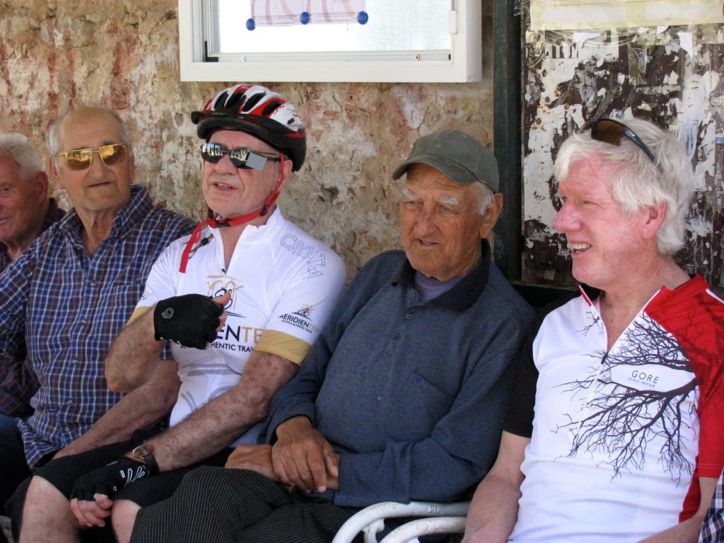 Cyclists and locals sharing a moment during a Croatian bike tour