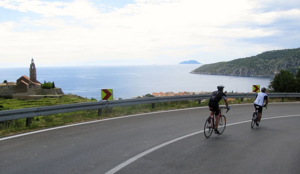 Cyclists riding a coastal road with sea views in Croatia