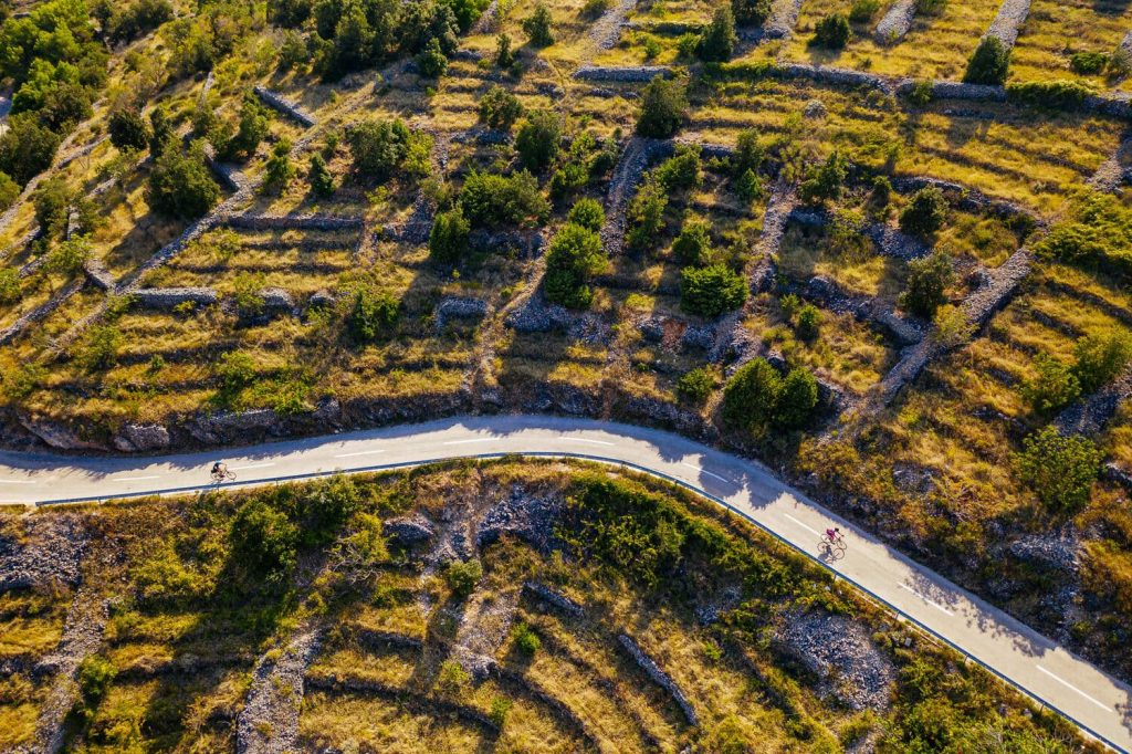 Cyclists riding through a Dalmatian stone landscape