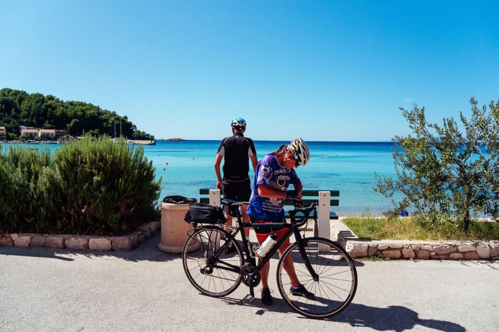 Cyclists stopping by turquoise sea during a Croatian cycling tour